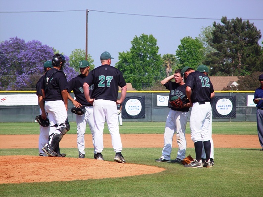Coach John Knott holds an early mound conference as Bonita successfully weathers an early storm by the Moors.