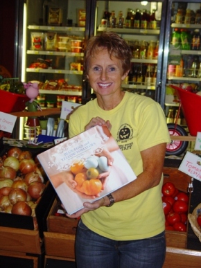 Farm Store Manager and Cal Poly Instructor Dawn Taccone holding a copy of the Southern California favorite, "Blue Eggs and Yellow Tomatoes" by Jeanne Kelley.