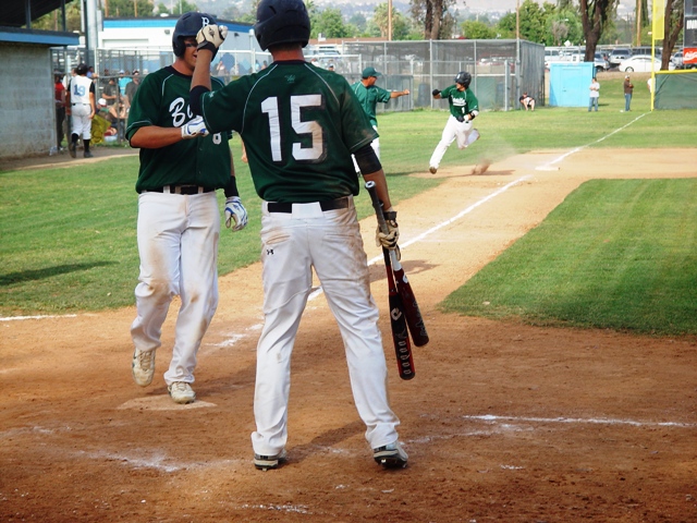 Matt Rodriguez, No. 15, greets Evan Highley who scored along with Brian Tuttle on a three-run homer in the top of the seventh by K.C. Huth, seen rounding third base.