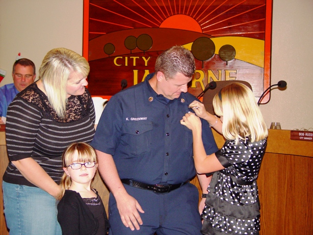 Madison Greenway pins her father, new fire captain Kevin Greenway, as his wife Lisa and daughter Laura celebrate the moment in their own way.
