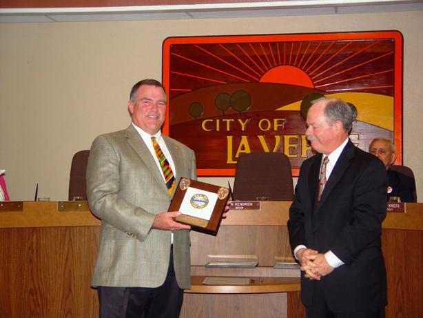 Steve Johnson accepts a plaque from Mayor Don Kendrick for his eight years of service to the city council.