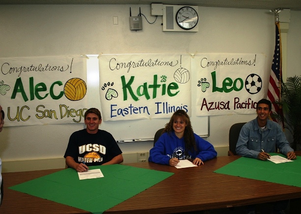 From left, college-bound seniors, Alec Williams, Katie Kirby and Leo Grigg,  show off their fancy signatures.