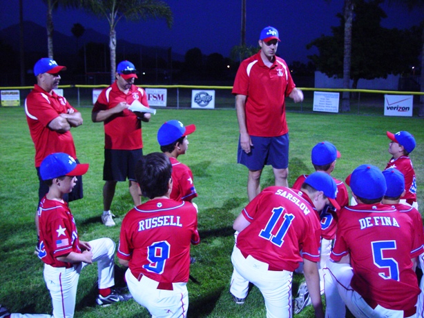 Manager Mike Kurnick and his coaches talk it up after the game.