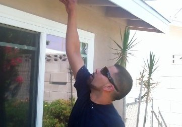 Victor points up to some dry rot under the eaves of a Montclair home.