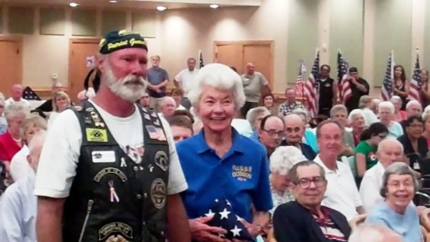 Friends of the 4th of July's Tim Morisson presents a U.S. flag to Margaret Peter Petersen, Navy, Yeoman, 2nd Class.