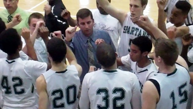 Damien coach Matt Dunn gathers his players during a time-out.